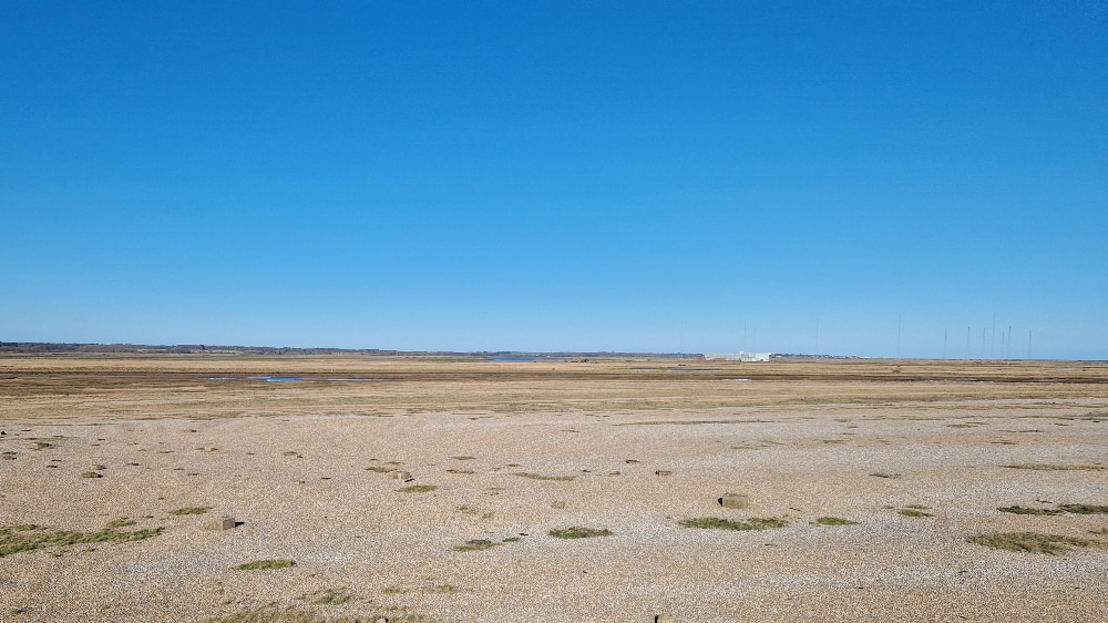 A view of the shingle fields of Orford Ness under a big blue sky